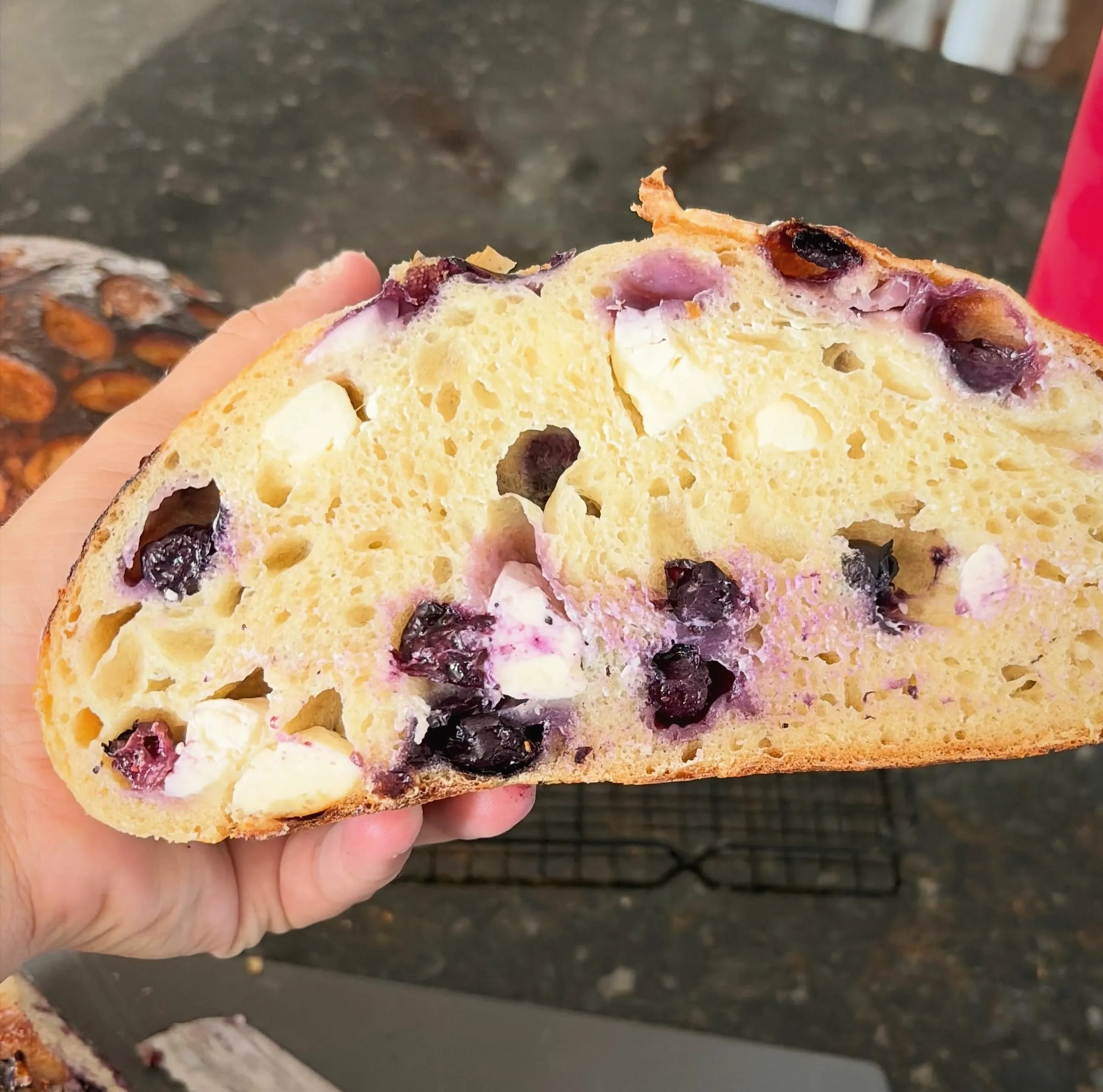 A sliced loaf studded with blueberries and cream cheese
